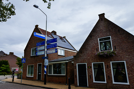 Edam, the Netherlands, August 2019. In a street in the historic center, a red brick house has a roof equipped with solar panels.