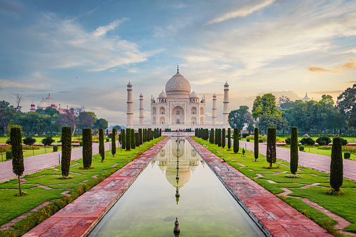 The famous Taj Mahal Mausoleum with reflection in the pond under moody sunrise twilight skyscape. The Taj Mahal is one of the most recognizable structures worldwide and regarded as one of the eight wonders of the world. Agra, India, Asia.