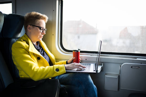 istock Woman is sitting in the train with laptop 1203701117