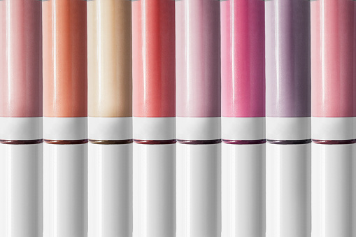 Palette of nude lip gloss tubes as a background