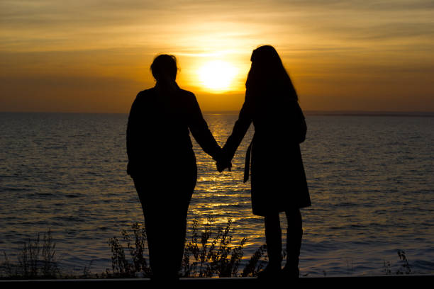 istock Girlfriends standing on railway rails holding hands on sunset background 1203703581