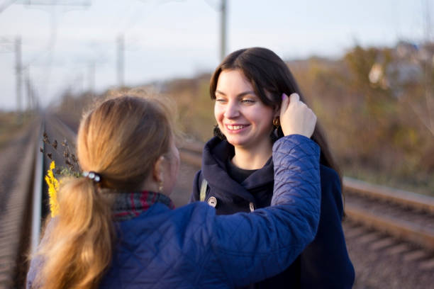 istock Girlfriends standing on railway rails holding hands on sunset background 1203703613