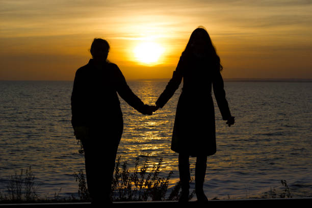 istock Girlfriends standing on railway rails holding hands on sunset background 1203703639