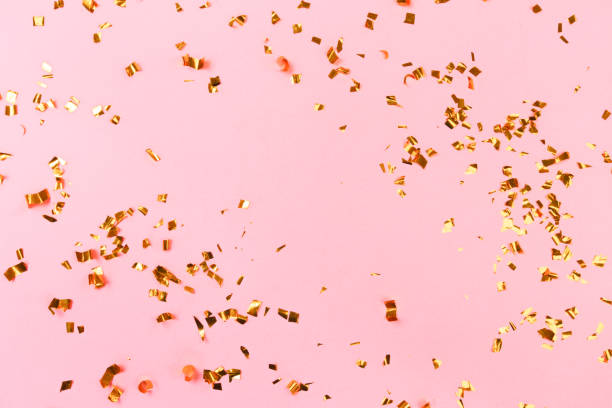 istock Golden flying sparkles on pink  holiday background. Festive backdrop for your projects. 1203703955