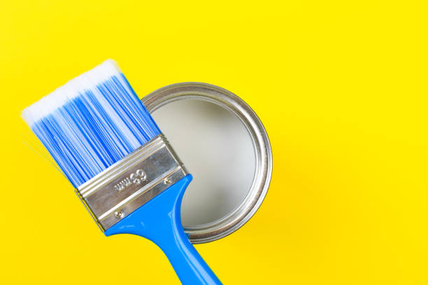 istock White Paint Can with Brush Top View On Yellow Background. 1203704038