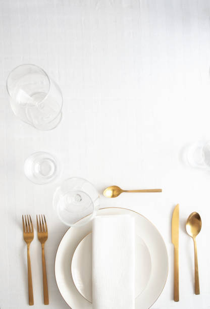 istock Table setting for elegant festive dinner with white porcelain plates, glasses, decorative textile and cutlery. Tableware background in white gold tone. 1203705955
