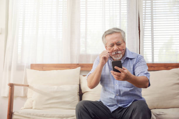 istock Older men move glasses down to look at the phone in the hand due to long sighted problems, which makes vision difficult.Health problems of the elderly. 1203706243