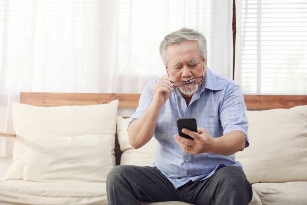 istock Older men move glasses down to look at the phone in the hand due to long sighted problems, which makes vision difficult.Health problems of the elderly. 1203706283