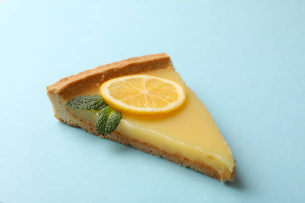 istock Lemon tart slice on blue background, space for text 1203707035