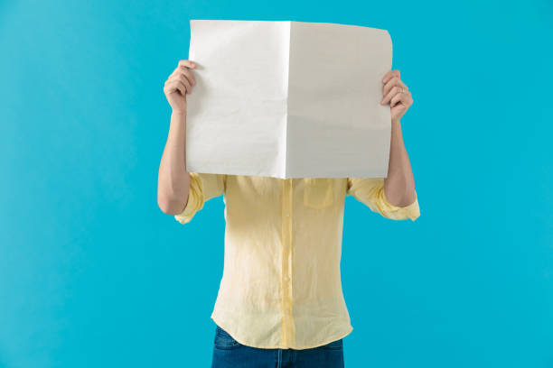 istock Young casual man hiding his face behind a newspaper 1203709627