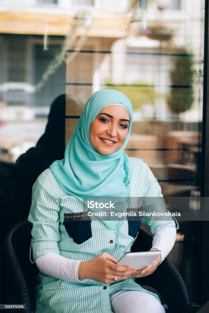 Beautiful Young Arabic Girl In Hijab Posing For A Camera At Street Cafe  Stock Photo - Download Image Now - iStock