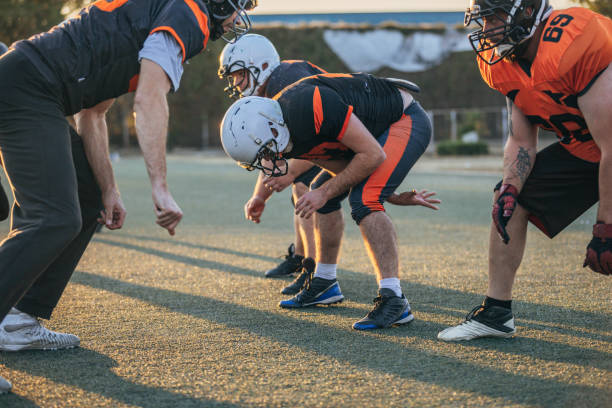 istock Football players playing a match on a field 1203710736