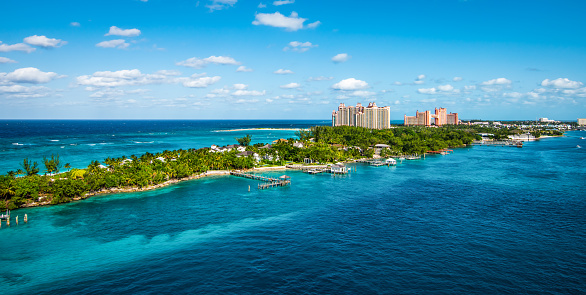 Bright and vibrant panoramic image with Paradise Island and palm trees close at the cruise port of Nassau in the Bahamas. Blue sky and some white clouds. Wide image.