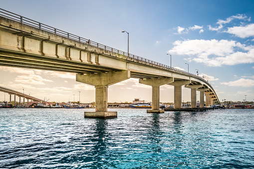 Bright image with concrete bridge that connect Paradise Island and Nassau in the Bahamas. Blue sky and some white clouds. Bridge over water.