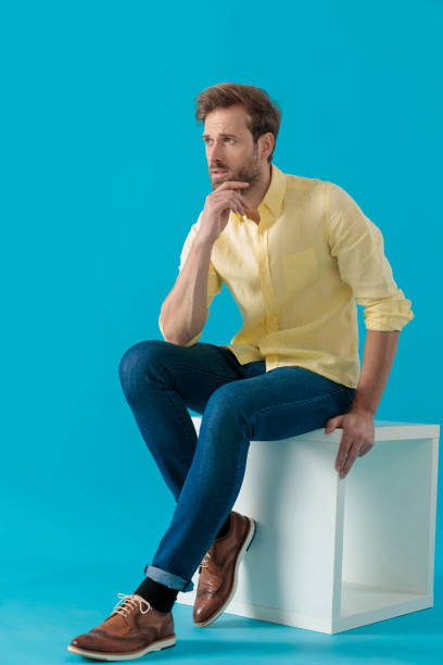 istock Casual man looking away with his hand on his chin 1203712401