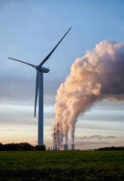 istock Single wind turbine and coal fired power plant 1203712605