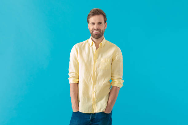 istock Happy casual man smiling with both hands in his pockets 1203712675