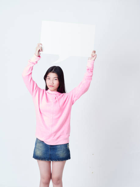 istock Cheerful girl smiling at camera and showing placard empty. 1203712761