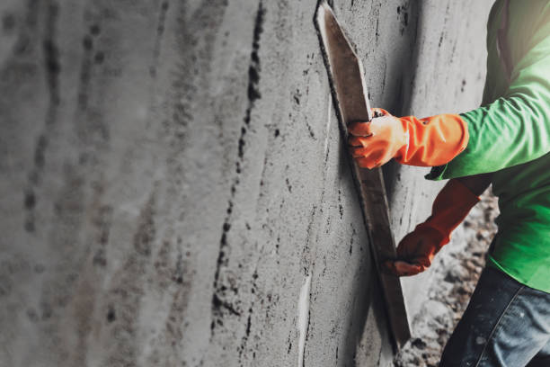 istock closeup hand worker plastering cement on wall for building house 1203713425