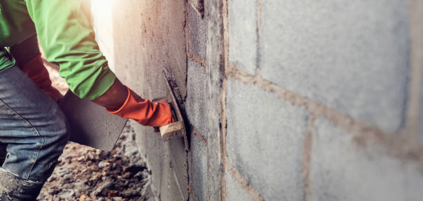 istock worker plastering cement on wall for building house 1203713431