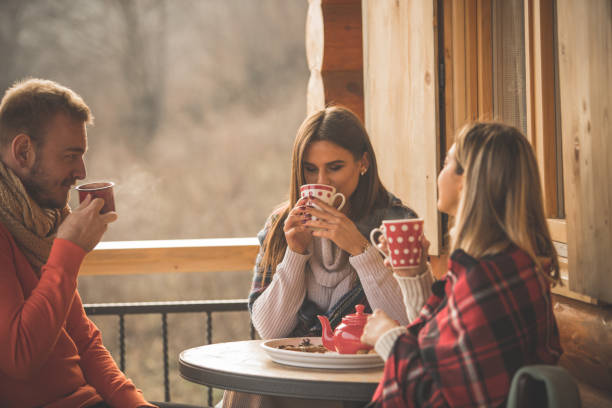 istock Three young people drinking tea outdoors on a patio together 1203714032