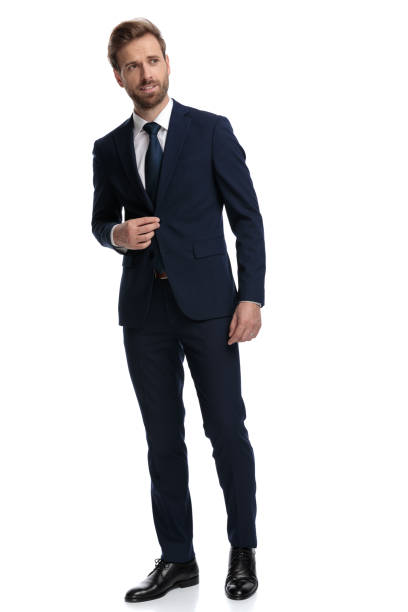 istock sexy young businessman looking to side and adjusting coat 1203717756