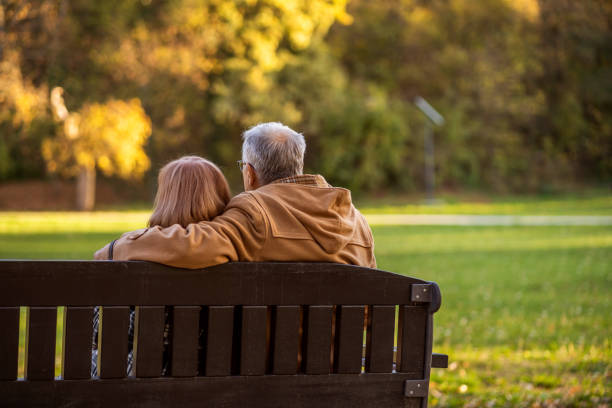 senor paar im park - senior adult women park bench 70s stock-fotos und bilder