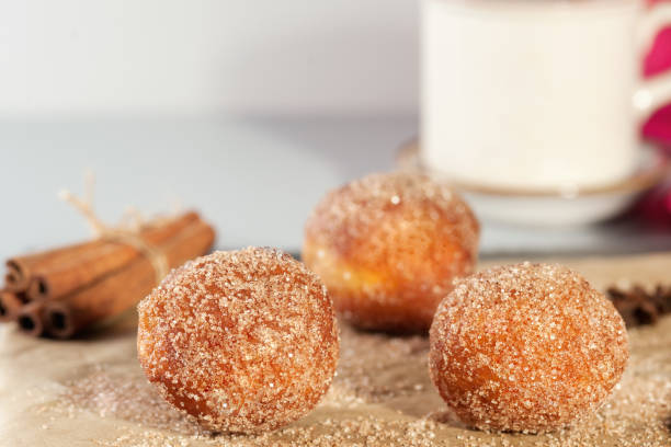 Donuts without holes. Tasty Donut holes sprinkled with cinnamon sugar on the brown paper on the table. Dieting abstract background.Horizontal . sprinkling powdered sugar stock pictures, royalty-free photos & images