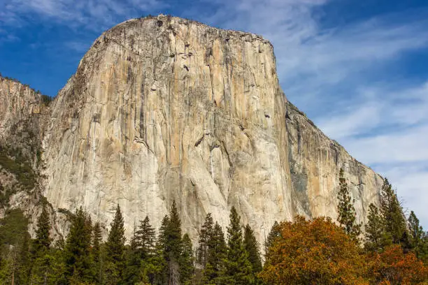Photo of El Capitan is a vertical rock formation in Yosemite National Park. Beautiful autumn colors with a blue cloudy sky daytime.