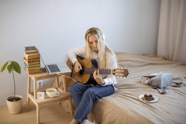 gir learning to play guitar at home - guitarist one person caucasian adult imagens e fotografias de stock