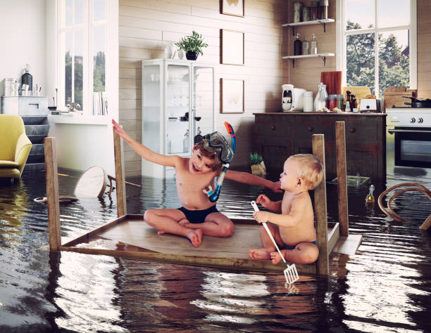 kids and flooding kids pday on the table while flooding in the kitchen. Photo and media photocombination social issues photos stock pictures, royalty-free photos & images