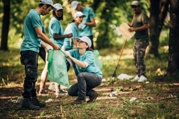 istock Volunteers cleaning garbage together in park 1203722216