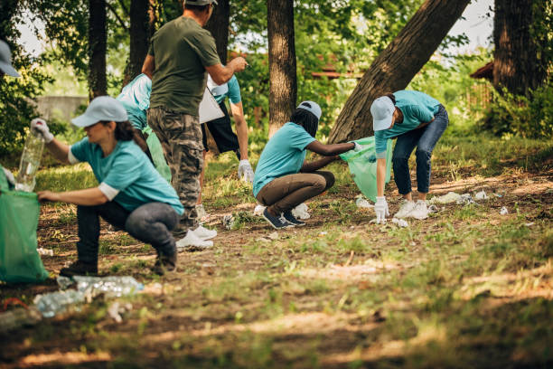 istock Volunteers cleaning garbage together in park 1203722437