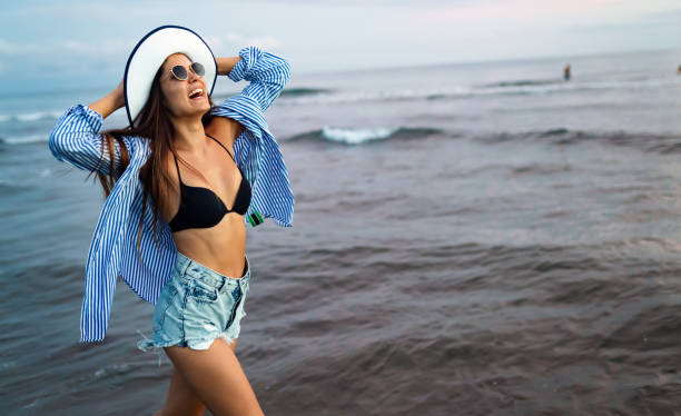 istock Beautiful woman on beach while summer vacation 1203723383