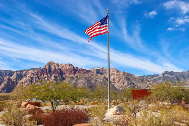 американский флаг развевается в центре для посетителей национального заповедника ред-рок-каньон недалеко от лас-вегаса. - nevada desert landscape cactus стоковые фото и изображения