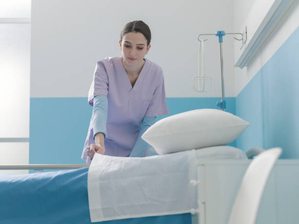 istock Expert young nurse making the bed at the hospital 1203723452