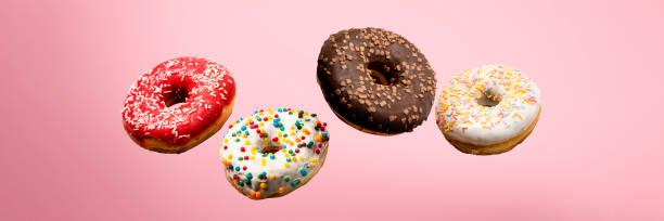 istock Donuts flying in the air on a pink background. Bakery, baking concept. Levitation. Banner 1203723929