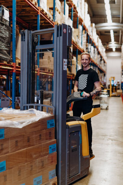 istock Employee in warehouse, driving forklift 1203724008