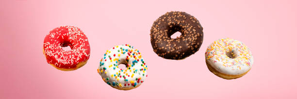 istock Donuts flying in the air on a pink background. Bakery, baking concept. Levitation. Banner 1203724469