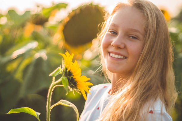 hermosa joven en un campo de girasoles. retrato de una joven al sol - pollen forecast fotografías e imágenes de stock