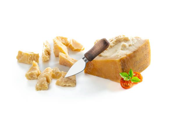 Parmesan Reggiano cheese isolated on white with basil cherry tomatoes and knife