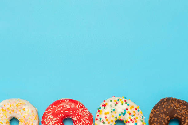 istock Donuts of different types on a blue background. Concept of sweets, bakery,. Banner. Flat lay, top view 1203725500