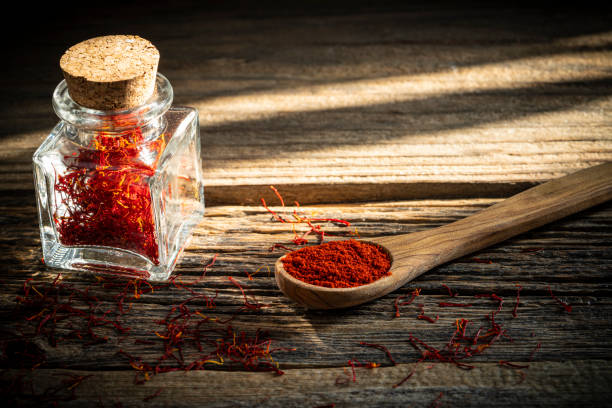 Saffron spice in glass bottle on rustic wooden table