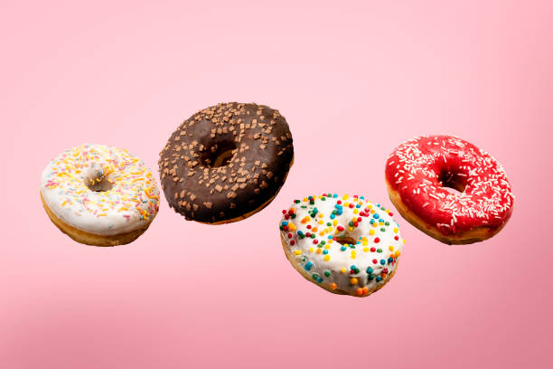 istock Donuts flying in the air on a pink background. Bakery, baking concept. Levitation. Banner 1203725847