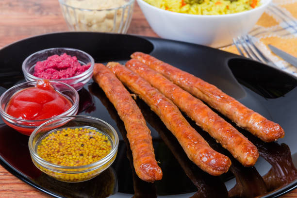 istock Grilled pork sausages, condiments on dish closeup in selective focus 1203726012