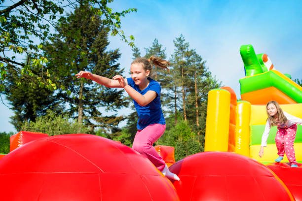 happy girls on inflate castle - inflatable child jumping leisure games imagens e fotografias de stock