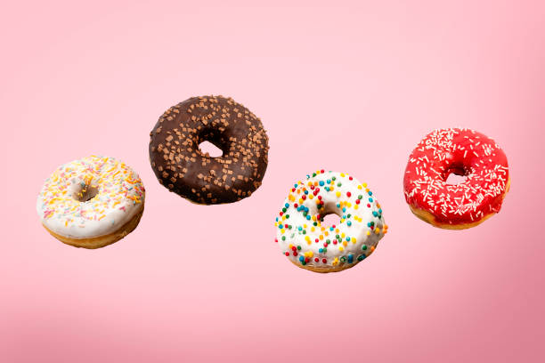 istock Donuts flying in the air on a pink background. Bakery, baking concept. Levitation. Banner 1203726137