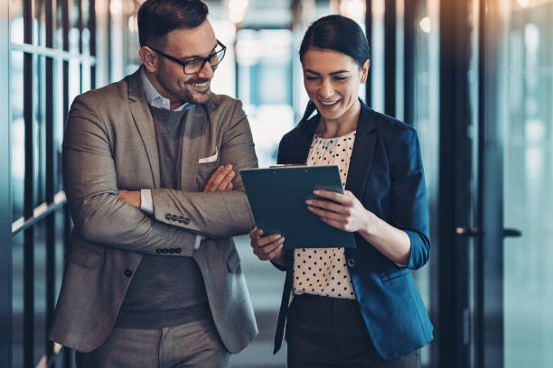 istock Two business persons looking at documents in the corridor 1203727147