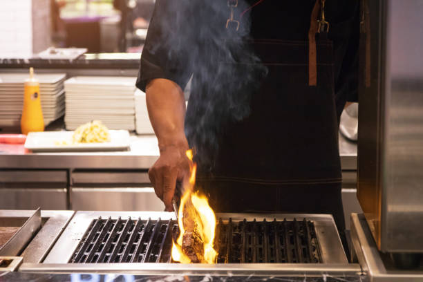 istock Chef cooked steak on grill with flames. 1203727658