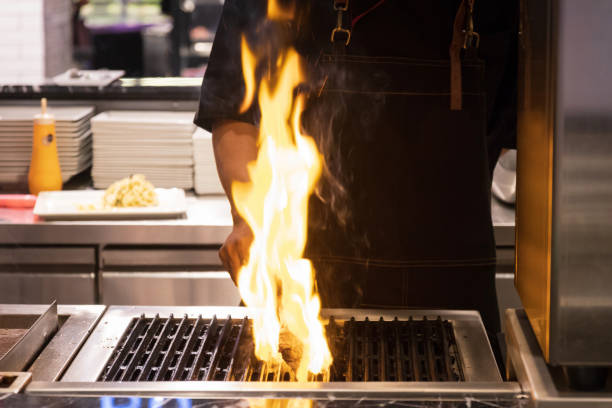 istock Chef cooked steak on grill with flames. 1203727694